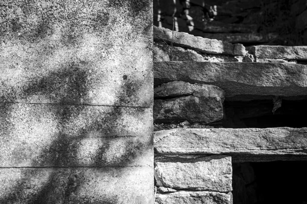Materialdetail der Casa Walser mit Betonoberfläche und Natursteinstruktur in Schwarz-Weiss