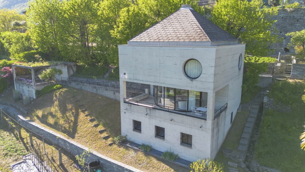 Aussenansicht der Casa Walser in Loco mit Sichtbetonkubus, Garten und Terrasse