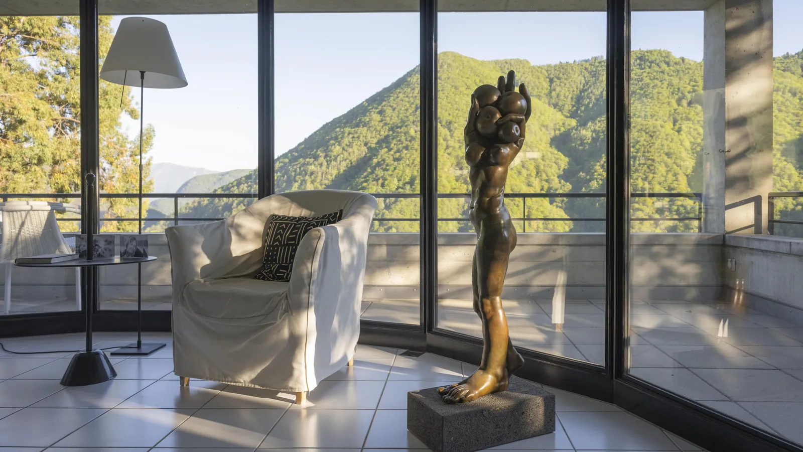 Sessel und Skulptur vor der Glasfront mit Blick ins Valle Onsernone